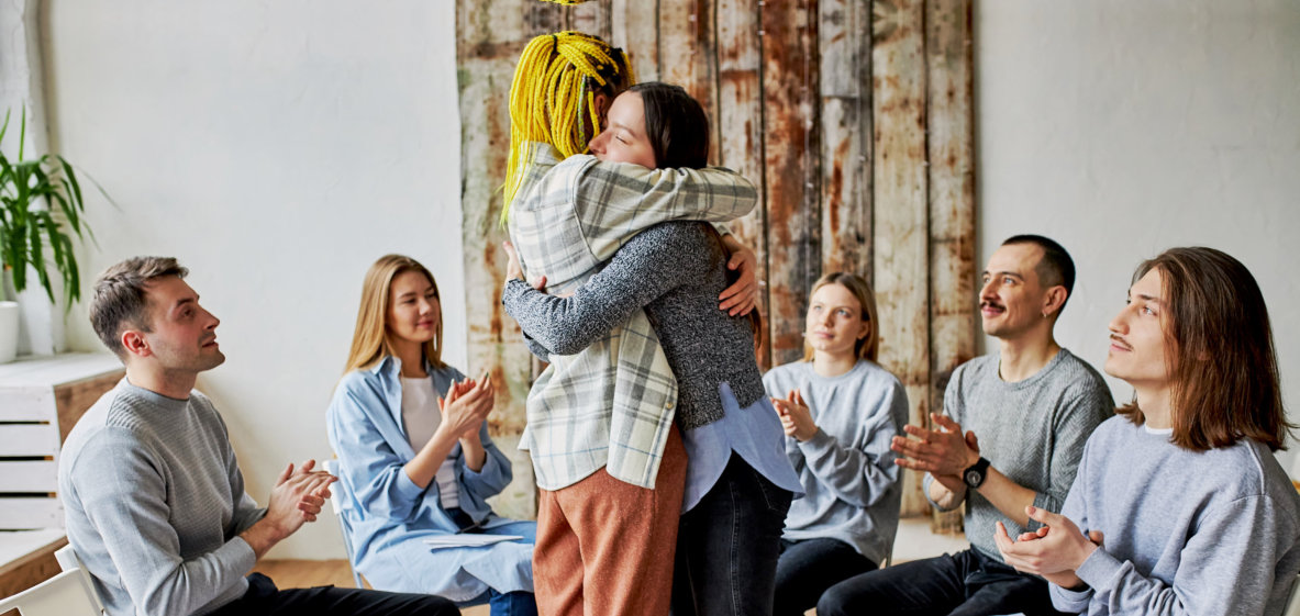 friends saying sorry to each other together with their peers