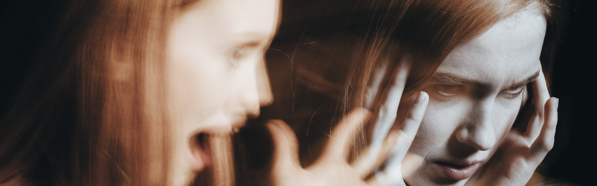 Girl with schizophrenia covering her ears to not hear the voice of her alter ego